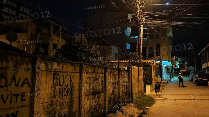 Dark street scene with graffiti and illuminated street lamps creates a tense atmosphere, Tirana, Albania