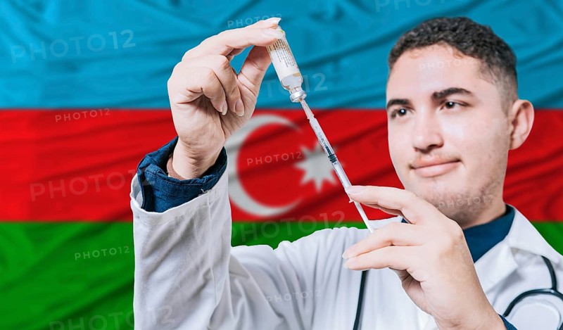 Doctor holding syringe on Azerbaijan flag background. Medical professional holding syringe with Azerbaijani flag in the background