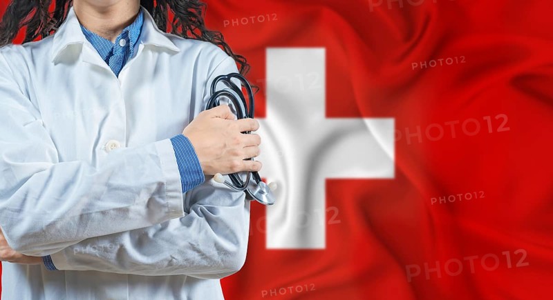 Healthcare professional with Switzerland flag background. Professional doctor holding stethoscope on Switzerland flag background