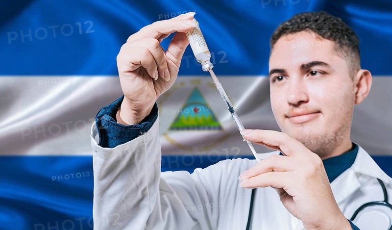 Doctor holding syringe on Nicaragua flag background. Medical professional holding syringe with Nicaraguan flag in the background
