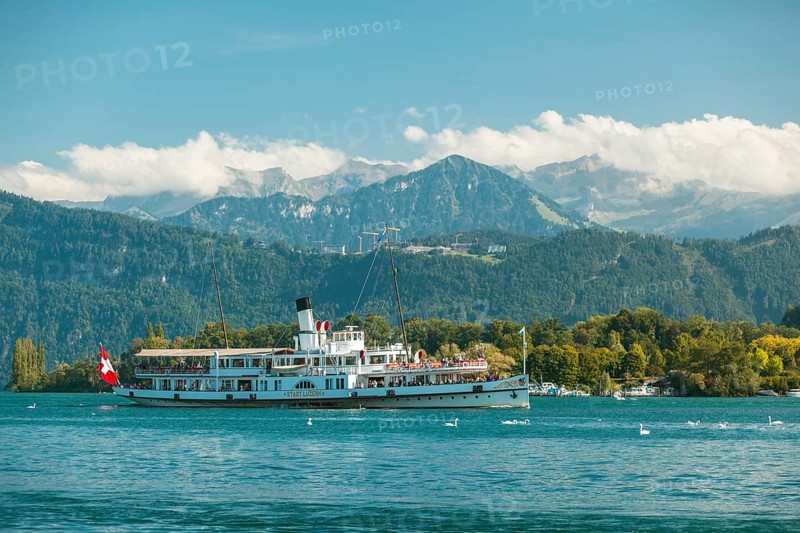 Lake Lucerne, Switzerland, Europe. A traditional boat on Lake Lucerne with the Swiss Alps in the background