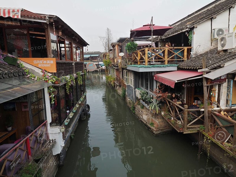 Charming rustic buildings with plants and wood elements along a quiet canal, Zhujiajiao Ancient Town, Shanghai, China
