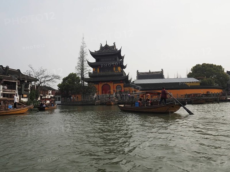 A riverbank pagoda with boats on water in a traditional Chinese landscape, Zhujiajiao Ancient Town, Shanghai, China