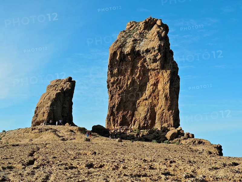 Two huge rock formations under a blue sky with people in the distance, Roque Nublo, Gran Canaria, Canary Islands, Spain