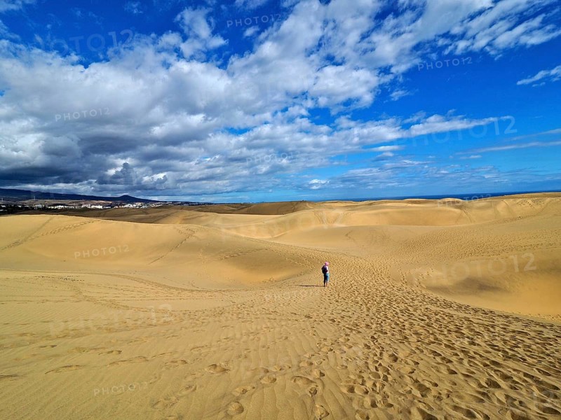Large dune landscape with footprints and a hiker under a blue sky with white clouds, dunes of Maspalomas, Gran Canaria, Canary Islands, Canary Islands, Spain