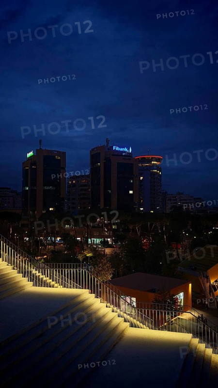 Nighttime city view with illuminated buildings and illuminated staircases in the foreground, Tirana, Albania