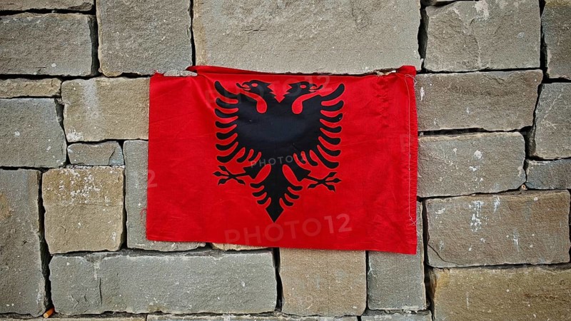 Albanian flag with black eagle on a red background on a stone wall, Tirana, Albania