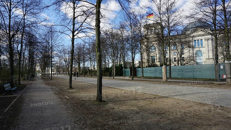 Promenade along the Reichstag with trees and sidewalk on a sunny day, deserted, without people, during corona, Berlin
