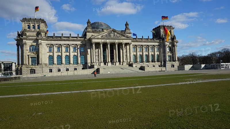 Historic building, Reichstag, Bundestag with dome and German flags on a sunny day, without people, during corona, Berlin