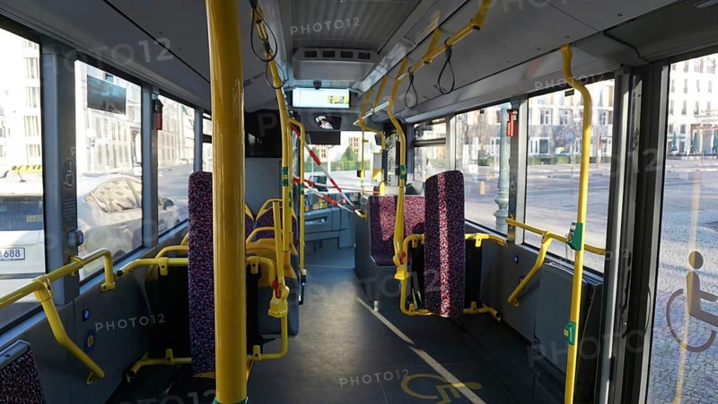 Interior of a public bus with empty seats, partly cordoned off with safety tapes and railings during corona, Berlin