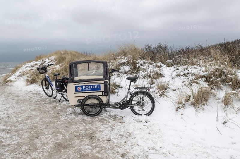 Police bike in snowy dunes, Langeoog, Lower Saxony, Germany