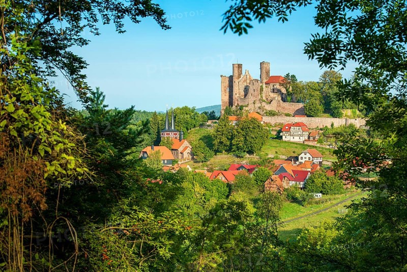 View through the forest of the ruins of Hanstein Castle and the small village of Rimbach, half-timbered houses and village church with half-timbered towers, Bornhagen, Eichsfeld, Thuringia, Germany