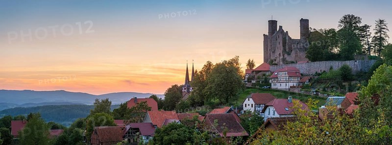 View of the ruins of Hanstein Castle and the small village of Rimbach with village church with half-timbered towers at sunset, Bornhagen, Eichsfeld, Thuringia, Germany