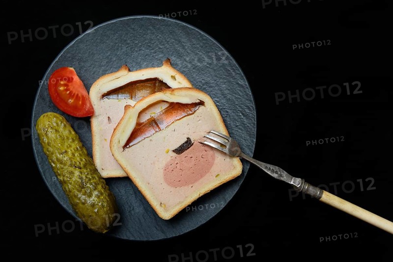 Battered pate on plate with cucumber and tomato