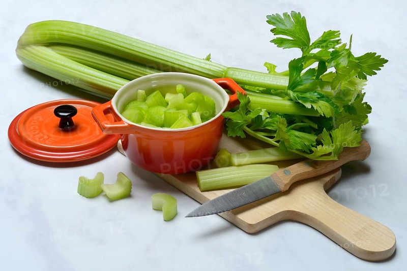 Celery stalks, pieces in pots with kitchen knife