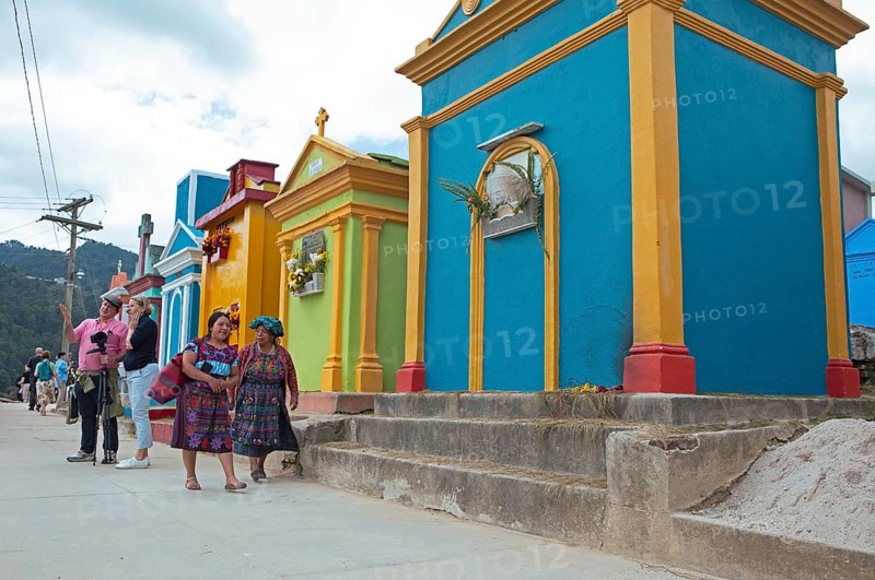 Mayan woman wearing traditional clothing at colorful graves at the cemetery in Chichicastenango, Highlands, El Quiché Department, Guatemala