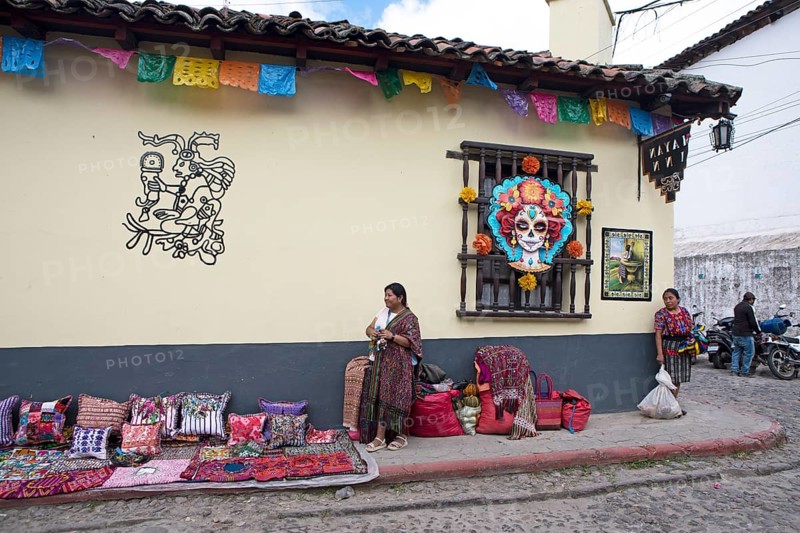 Mayan woman wearing traditional clothing on a decorated house façade, Chichicastenango market, Highlands, El Quiché Department, Guatemala