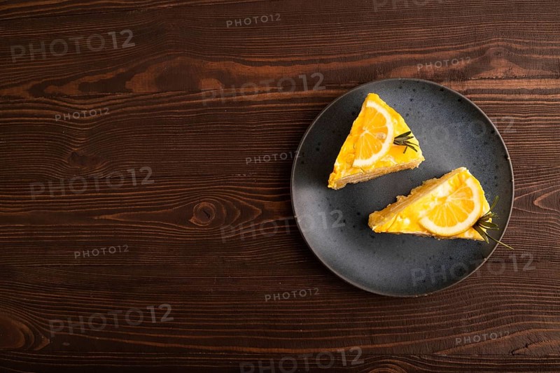 Lemon cake on brown wooden background, top view, flat lay, copy space