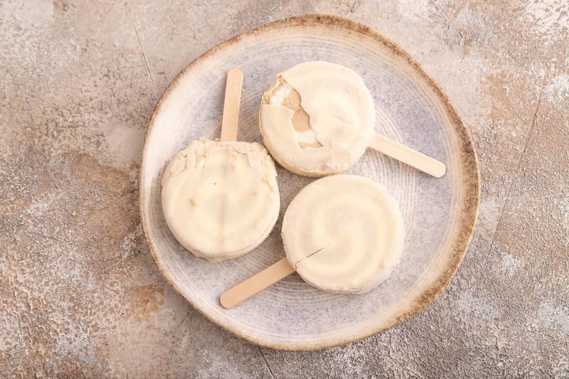 ?hocolate Ice cream in white glaze, on brown concrete background, top view, flat lay, close up, minimalism