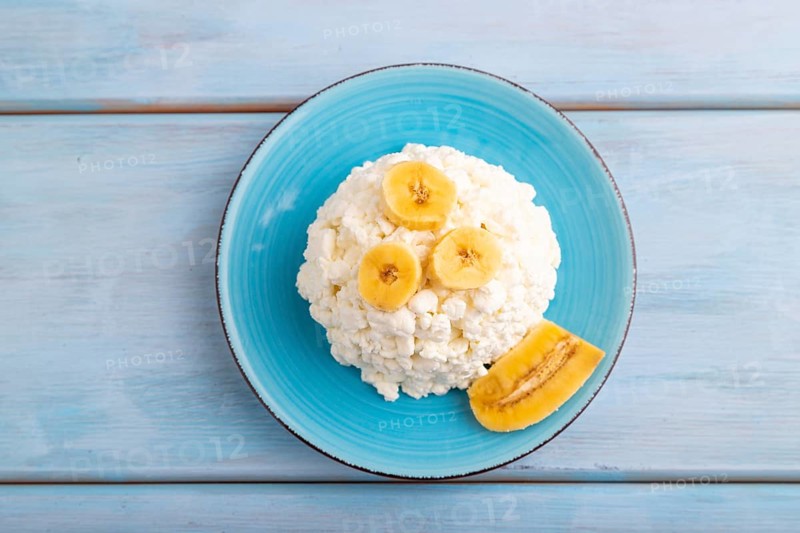 White ?ottage cheese, Curd, with Banana on blue wooden background, top view, flat lay, close up