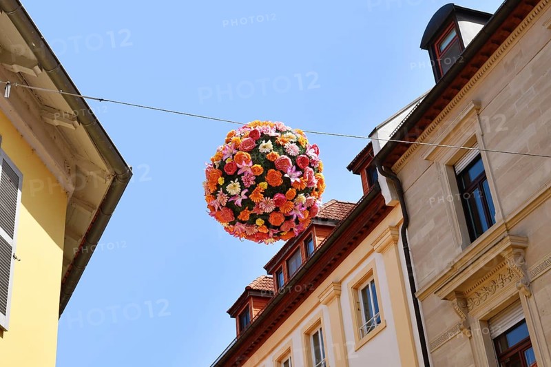 Ettlingen, Germany - August 13th 2025: Floral sphere of flowers hanging above street as summer decoration