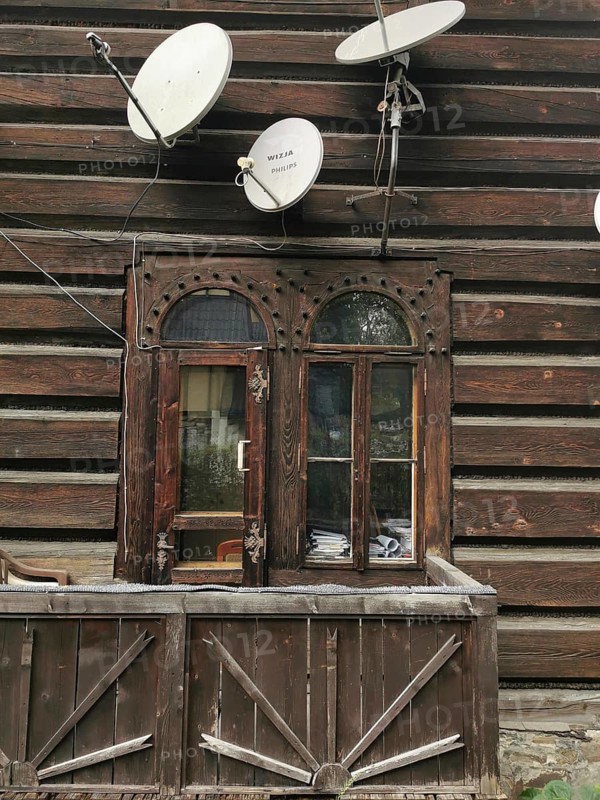 Rustic wooden house with old windows and several satellite dishes, High Tatras, Poland