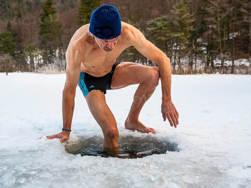 Man with cap, 55, climbs into an ice hole for ice bathing, Thumsee, Bad Reichenhall, Berchtesgadener Land, Upper Bavaria, Bavaria, Germany