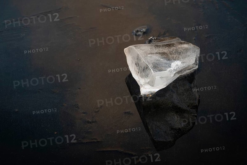 Piece of ice lies on the frozen surface of a lake, Finland