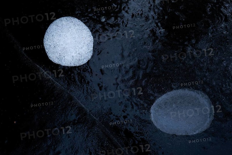 Air bubbles in the ice of a frozen lake in winter, Finland