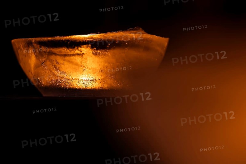Ice bowl illuminated by a burning tea light, winter, Finland
