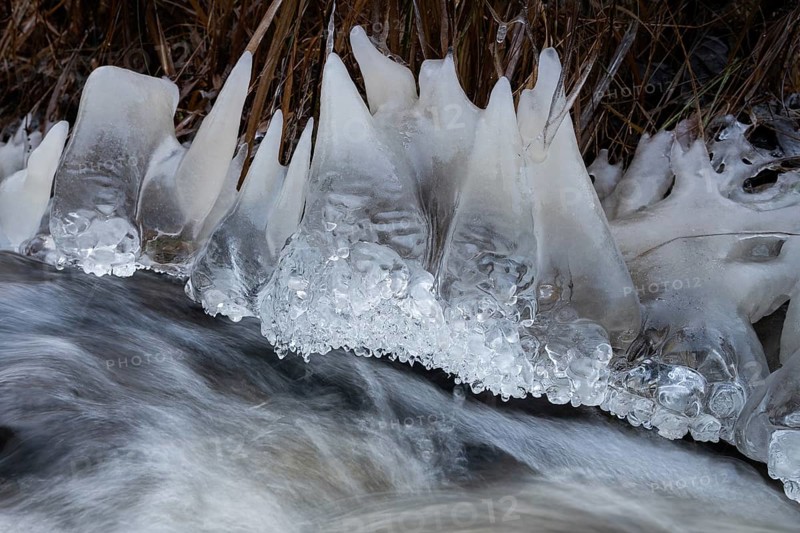 Teeth-like ice sculptures on the banks of a fast-flowing stream, winter, near Heinola, Finland