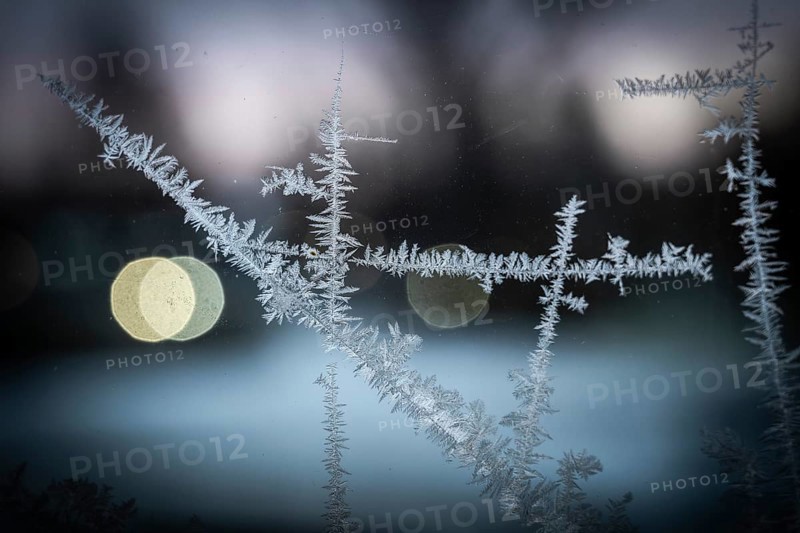 Ice crystals, close-up of frost on glass with bokeh through lights in the background, wintry atmosphere, Finland