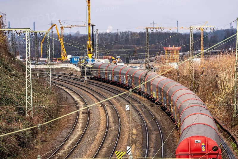 Freight train on the railway line at the Duisburg-Kaiserberg motorway junction, constricted lanes, heavy traffic, complete conversion and construction of the A3 and A40 intersections, all bridges, ramps, roadways are renewed and partly extended, 8-year construction period, railway bridges running there will also be renewed, North Rhine-Westphalia, Germany