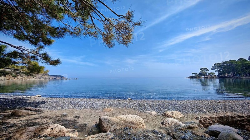 A peaceful pebble beach with a view of the calm sea and clear skies, Antalya, Turkey