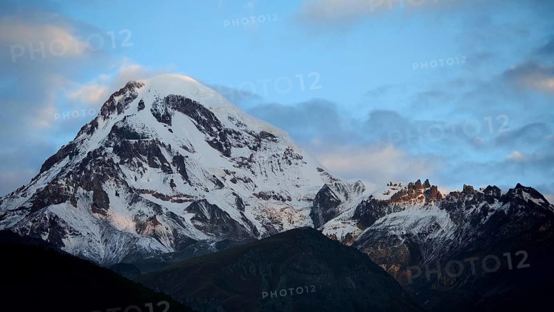 Majestic snow-covered mountain under cloudy sky, Kazbek, Stepantsminda, Georgia
