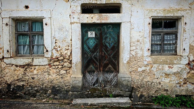 Weathered stone wall with old wooden door and two windows, Franconian Switzerland, Upper Franconia