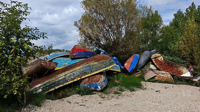 Abandoned, colorful boats are piled up in a natural environment, North Macedonia