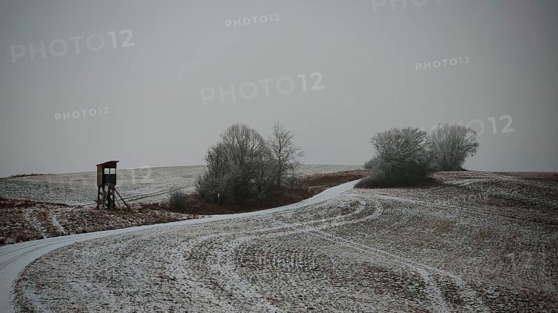 Cold winter day with a snowy dirt road and raised chair, Franconian Forest nature park Park