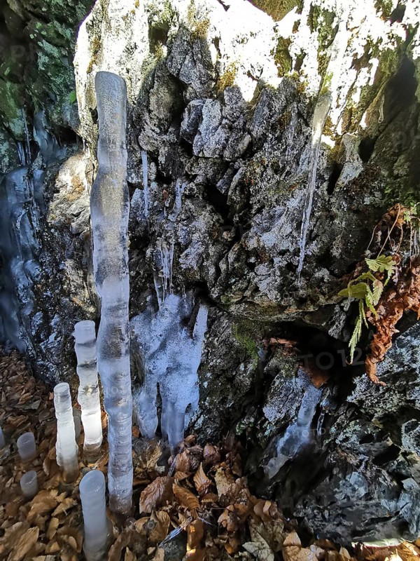Icicle ice stalagmites in a shady cave, Franconian Forest