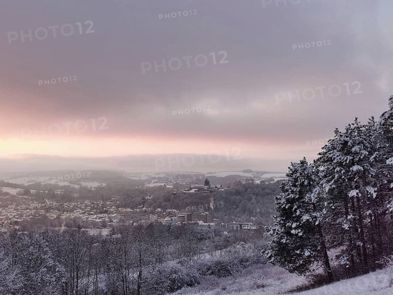 Snowy hills with a view of a village at sunset, view of Rosenberg Fortress and the town of Kronach, Upper Franconia