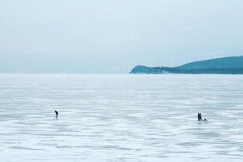 Lake Baikal, Siberia, Russia. People in the vast frozen lake in deep winter