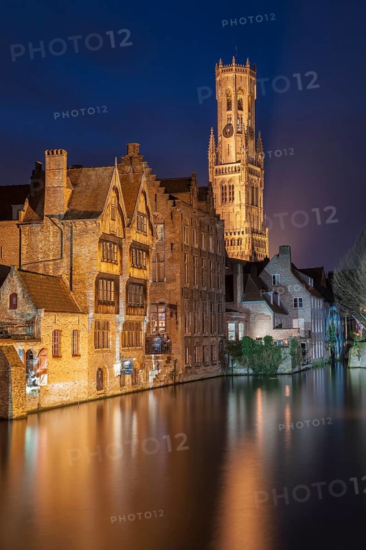 Bruges. Belgium. Flanders. Historic Houses and Town Hall tower in the old district overlooking a canal. UNESCO