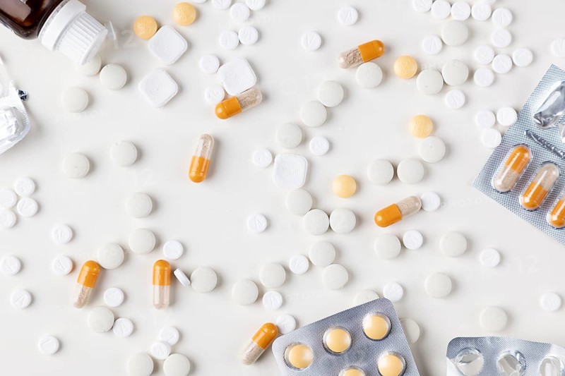 Different tablets and blister packs on a bright background