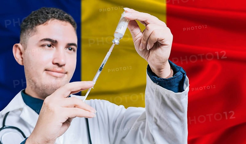Doctor holding syringe on Romania flag background. Medical professional holding syringe with Romanian flag in the background