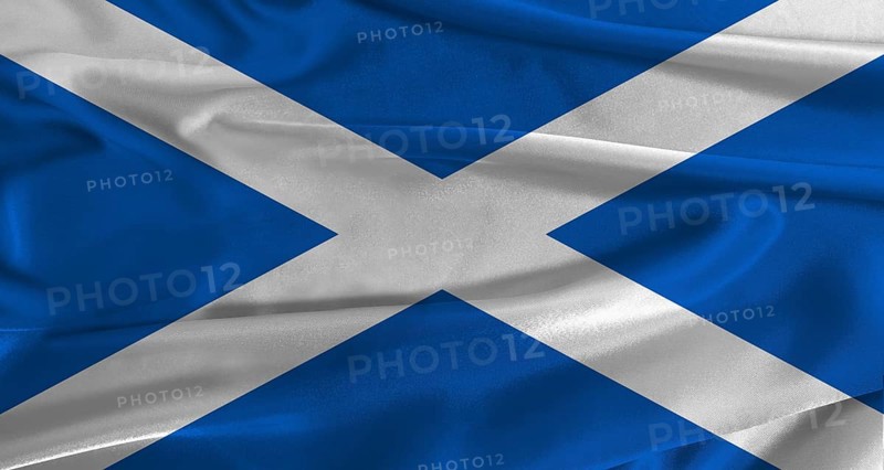 Flag of Scotland with fabric textured background. Close up of National flag of Scotland with realistic texture