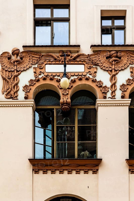 Czyncielow Art Nouveau house façade with intricate terracotta reliefs depicting snakes and an Aesculapian rod, Krakow, Poland