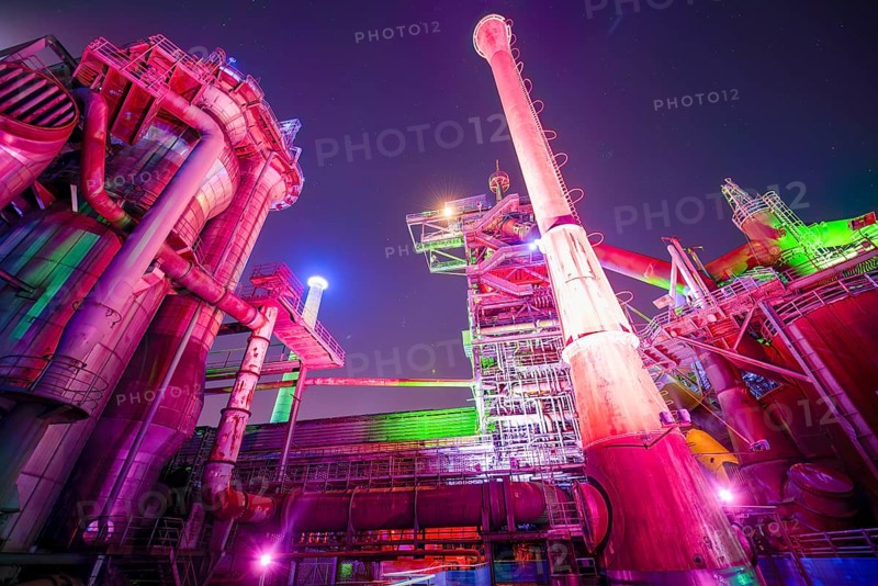 Colour-illuminated industrial ruins at night with pipes and futuristic character, Landschaftspark Duisburg Nord, Duisburg, North Rhine-Westphalia, Germany