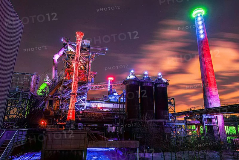 Night view of an illuminated industrial plant with colored lights and clouds in the sky, Landschaftspark Duisburg Nord, Duisburg, North Rhine-Westphalia, Germany