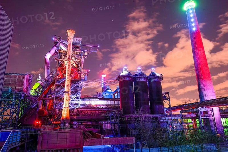 Colourful lighting on industrial buildings with visible chimney, Landschaftspark Duisburg Nord, Duisburg, North Rhine-Westphalia, Germany