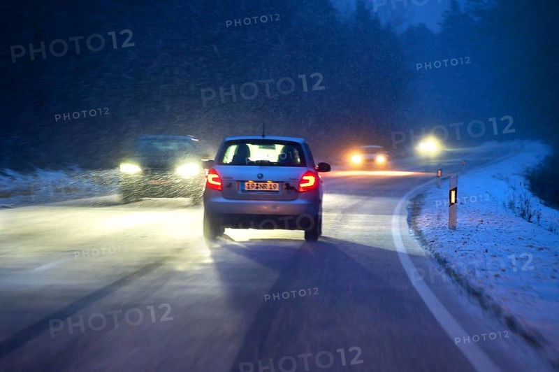Cars during night snow flurries on B2, Heroldsberg, Middle Franconia, Bavaria, Germany